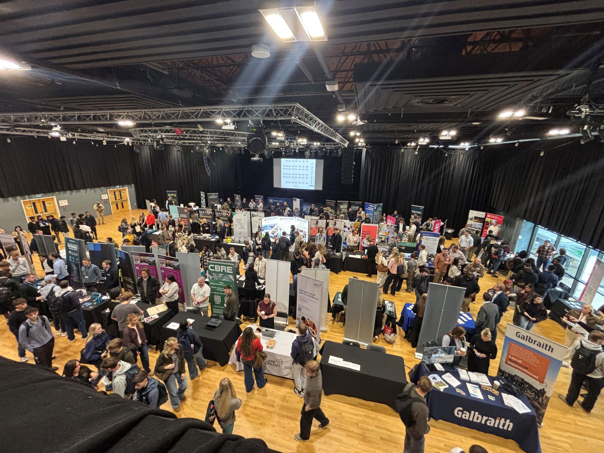 An elevated view of students and exhibition stands across the Built Environment Careers Fair hall