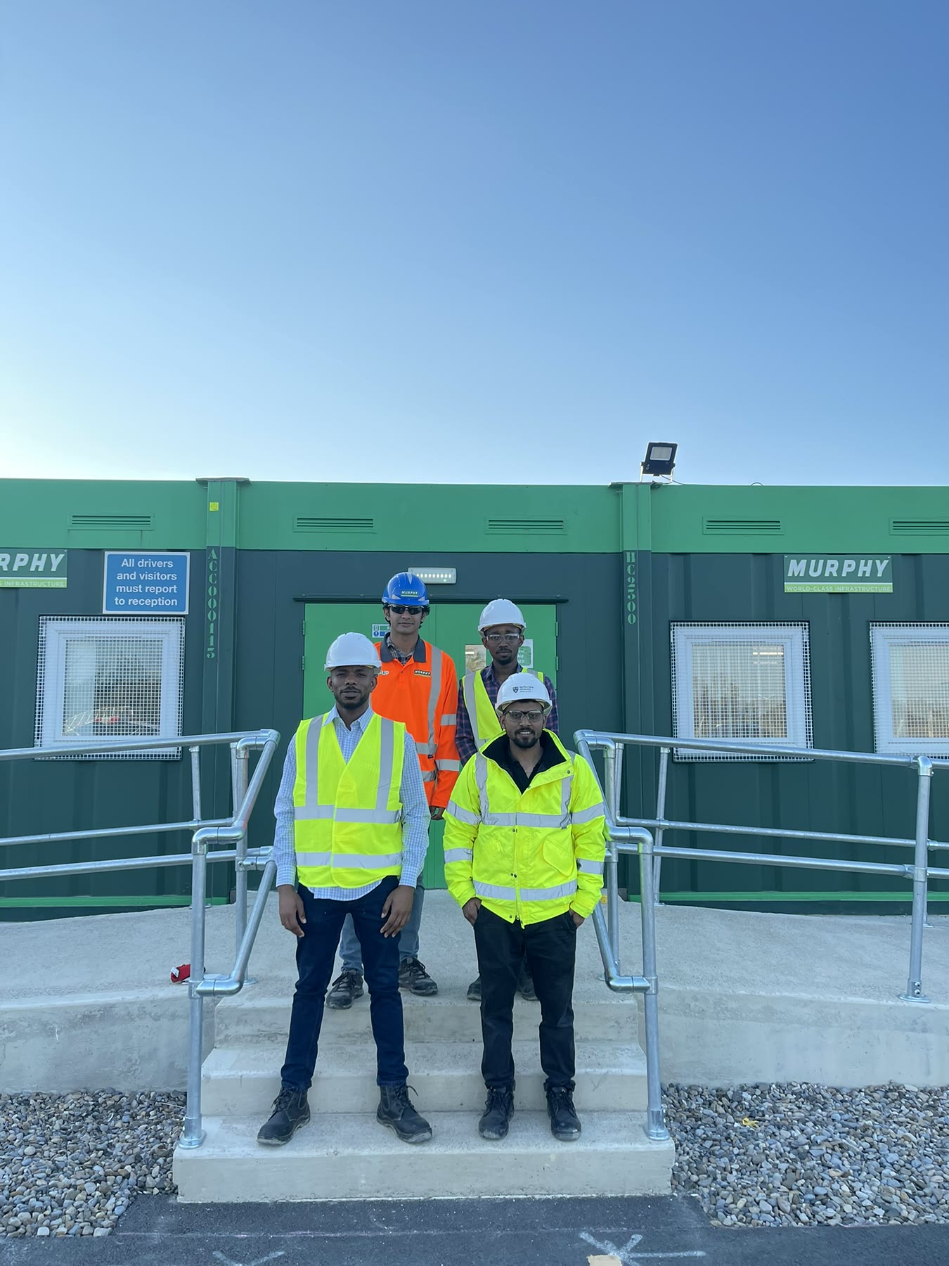 Four Northumbria Construct participants wearing hard hats and high-visibility clothing during the CIOB Site Visit