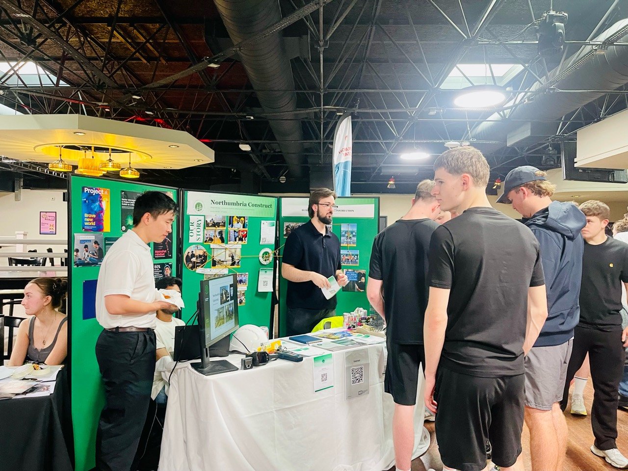 Volunteers speaking with students visiting the Northumbria Construct stand